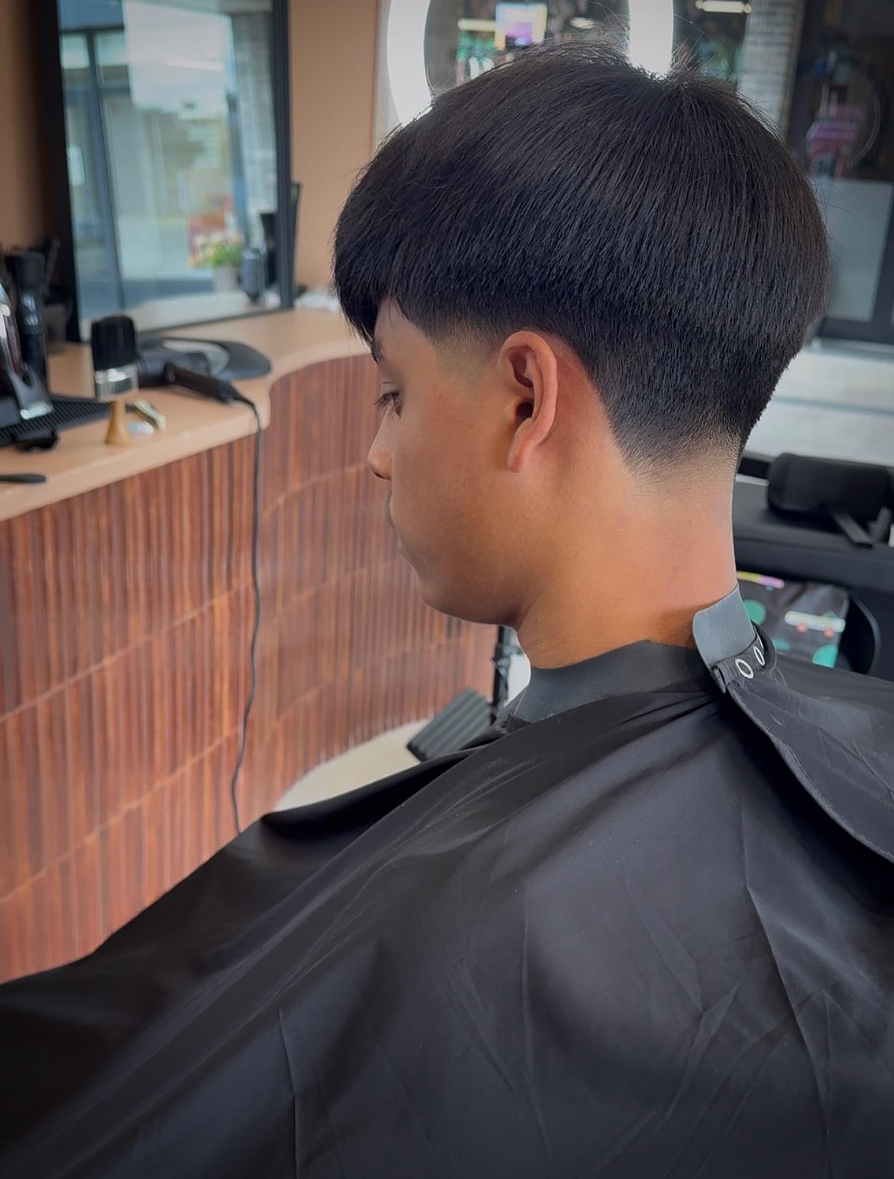 Low taper fade met lange bovenkant, geknipt in de studio